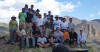 Group posing on turbidites, Wildhorse project; spires of dacite flow to the right background