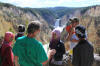 Don Fisher talks to Nelisa (purple), Nur (pink), Rizal (backwards hat), and Pat (field book), Lower Falls at Yellowstone.