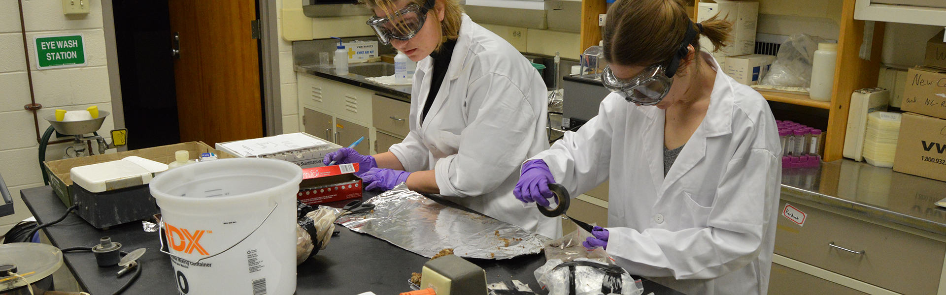 sarah ivory in lab unwrapping rock samples