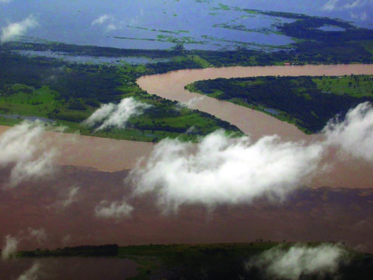 winding amazon river with brown color water and clouds above